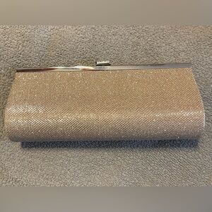 Rose champagne colored clutch with chain shoulder strap included.